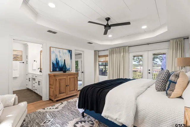 a bedroom with a large bed and wooden floor