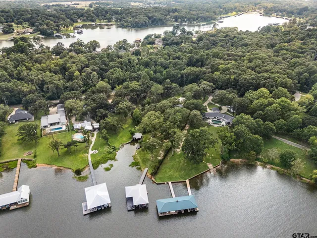 an aerial view of a house with a yard and lake view