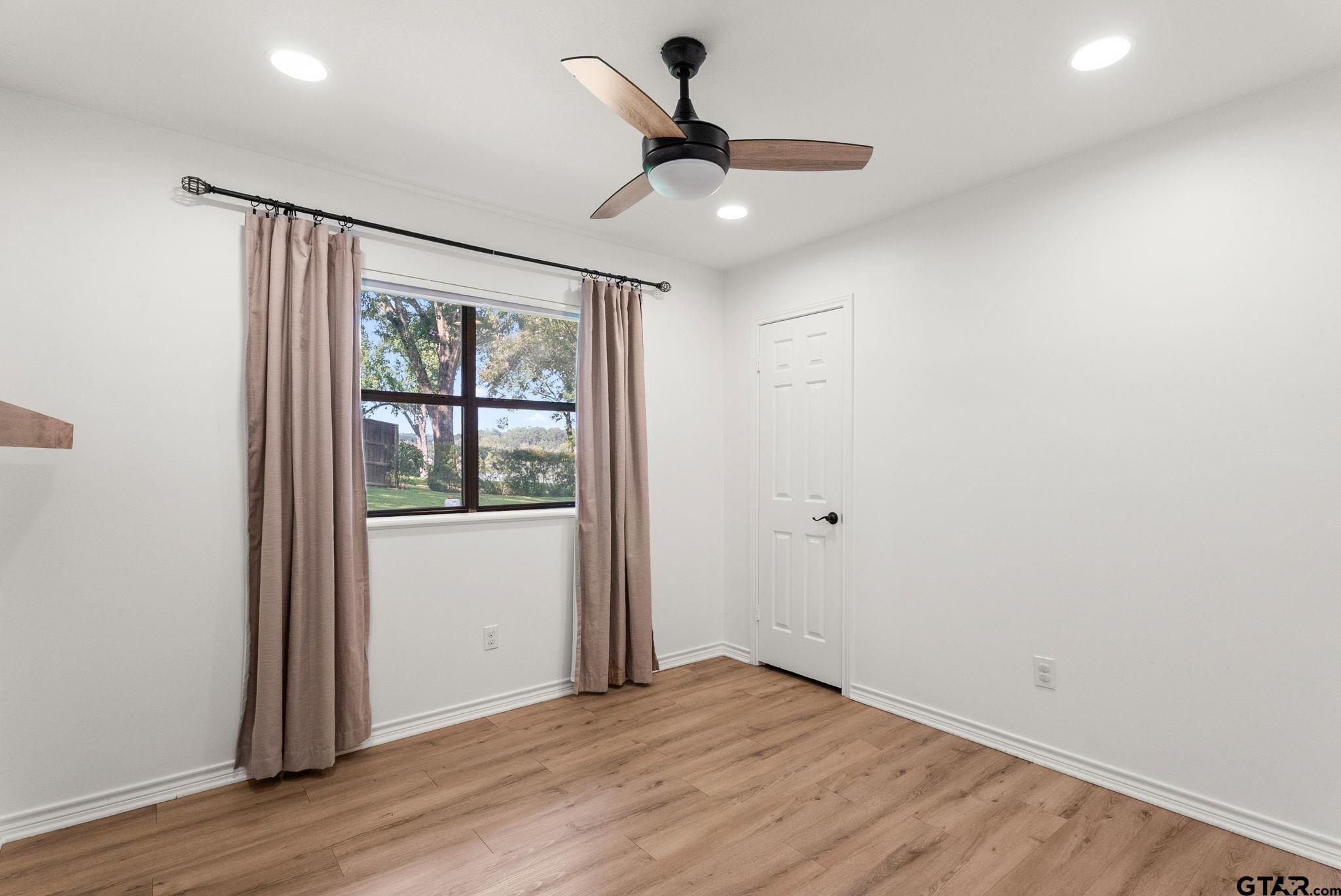 13235 Peninsula Road Whitehouse, TX 75791 - Photo 21 of 48 a view of an empty room with wooden floor and a window