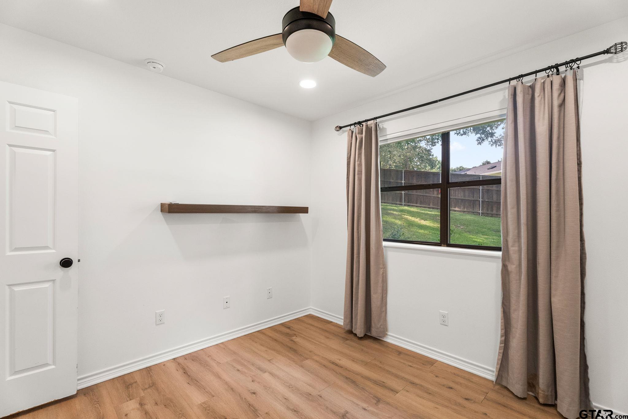 13235 Peninsula Road Whitehouse, TX 75791 - Photo 22 of 48 a view of an empty room with wooden floor and a window