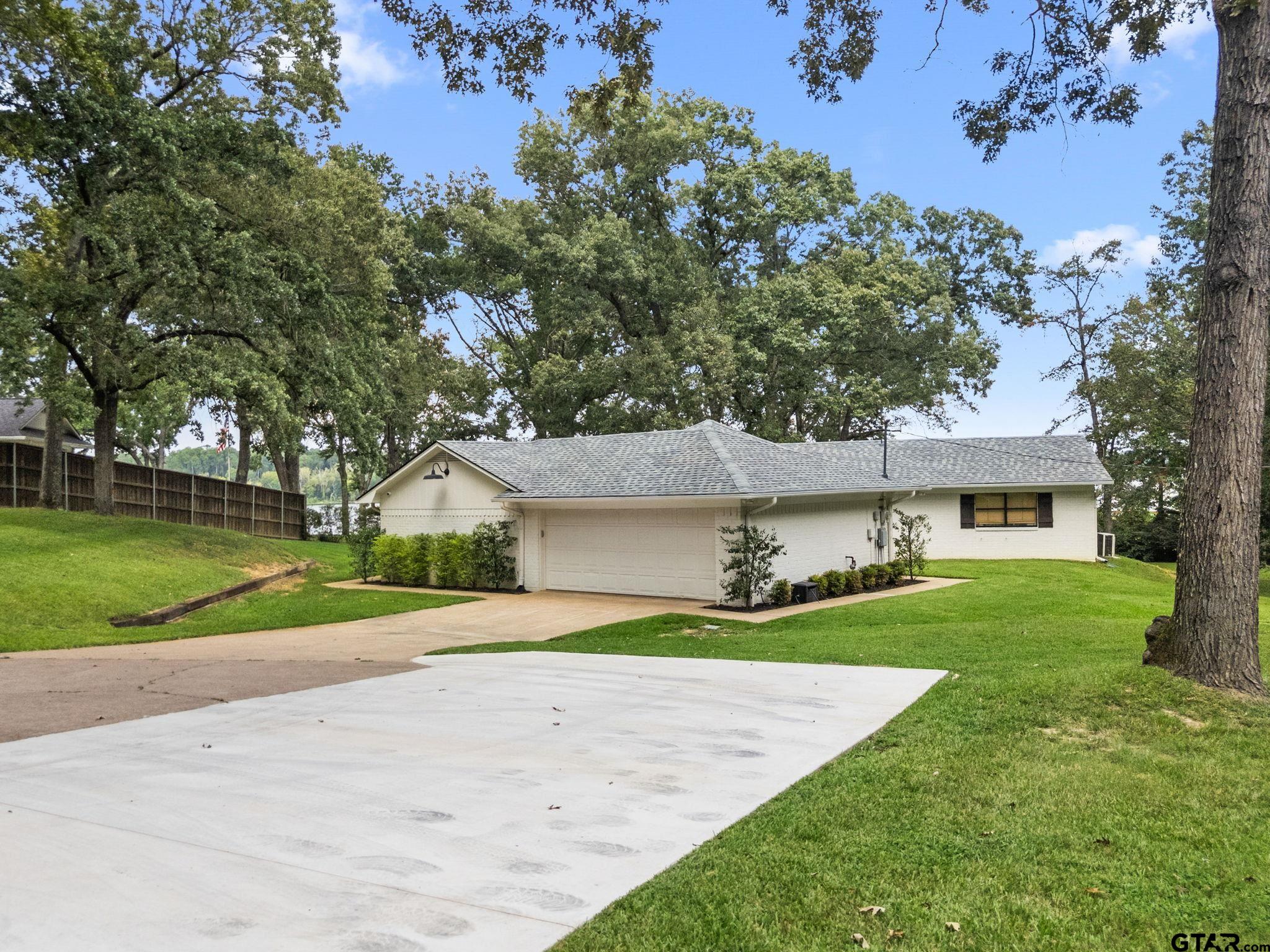 13235 Peninsula Road Whitehouse, TX 75791 - Photo 45 of 48 a front view of a house with a yard and garage