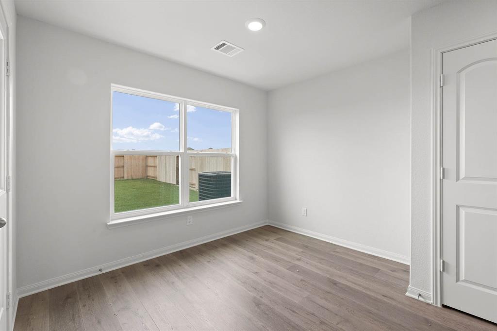 1341 Wind Drift Way Fort Worth, TX 76131 - Photo 4 of 8 an empty room with wooden floor and windows
