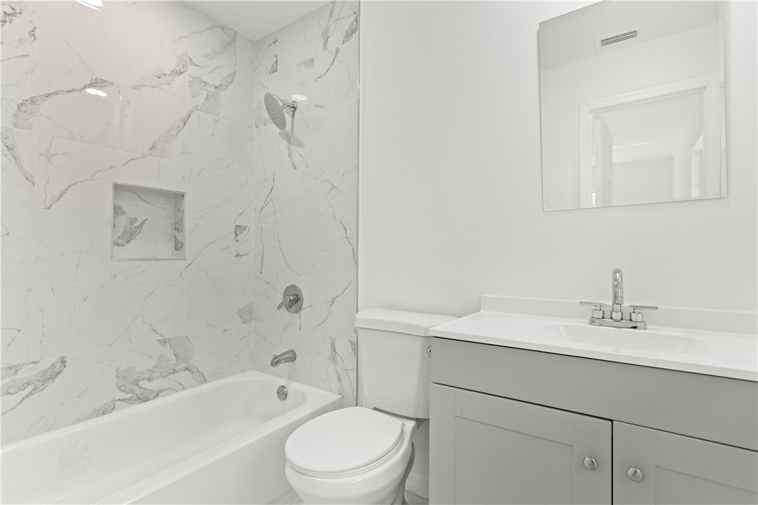 1406-1408 36th Avenue Vero Beach, FL 32960 - Photo 13 of 16 a bathroom with a sink a toilet and bathtub