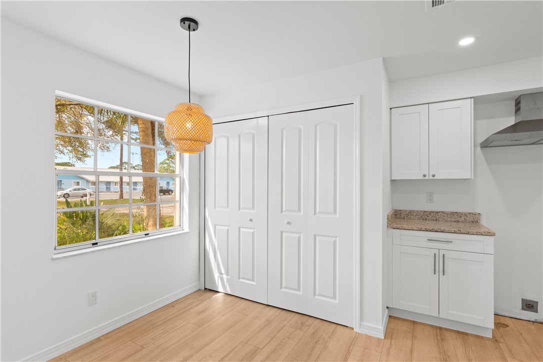 1406-1408 36th Avenue Vero Beach, FL 32960 - Photo 3 of 16 a view of an empty room with a window and wooden floor