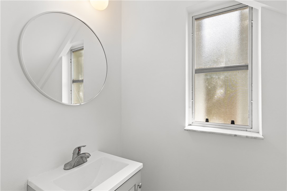 1406-1408 36th Avenue Vero Beach, FL 32960 - Photo 6 of 16 a bathroom with a sink a mirror and window