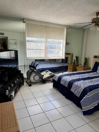 a spacious bedroom with a bed a table and a large window