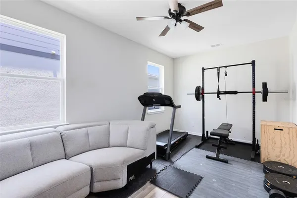 a living room with furniture and a ceiling fan