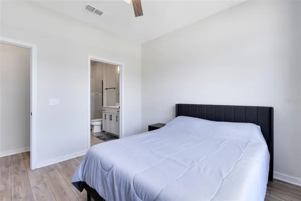 a bedroom with a bed and wooden floor