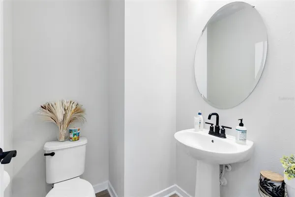 a bathroom with a sink a toilet and a mirror