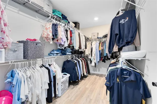 a view of walk in closet with clothes and shoes