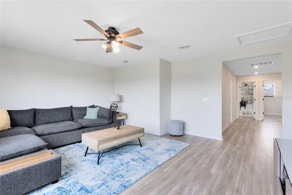 a living room with furniture and a wooden floor