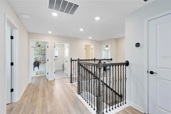 a view of a hallway with wooden floor and windows
