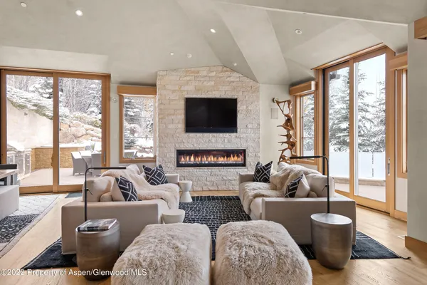 a living room with furniture a large window and a flat screen tv