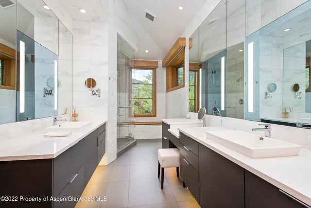 a large bathroom with a double vanity sink large mirror and a bathtub