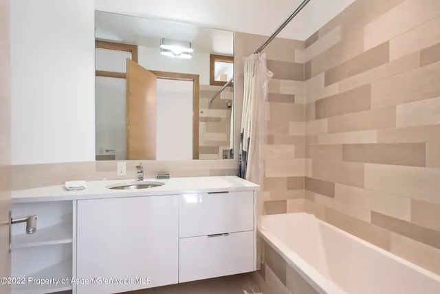 a bathroom with a tub sink and mirror