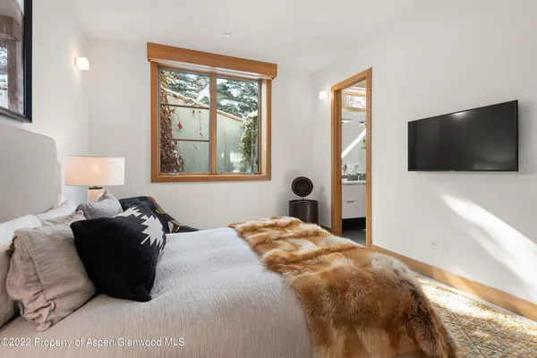 a bedroom with a bed tv and window