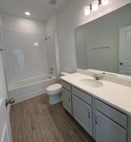 a white bath tub sitting next to a white sink and vanity