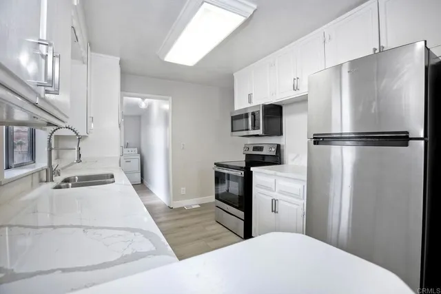 a kitchen with stainless steel appliances a refrigerator sink and microwave