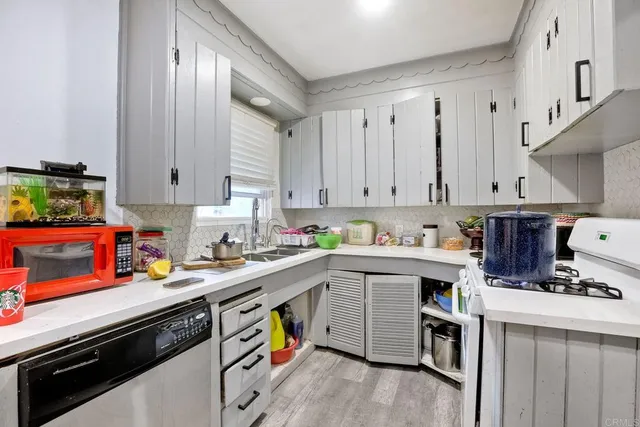a view of kitchen with stainless steel appliances sink stove and cabinets