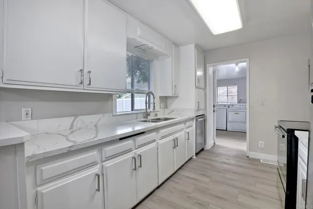 a kitchen with granite countertop white cabinets and a sink