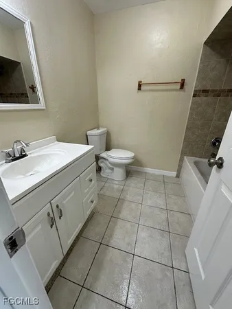 a bathroom with a granite countertop bathtub and toilet