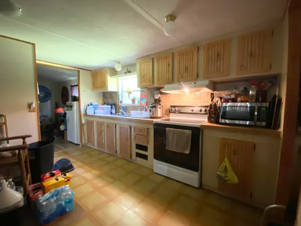 a kitchen with stove a sink and cabinets