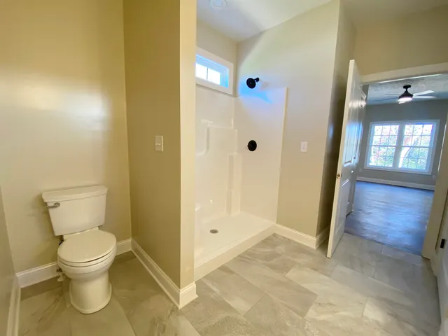 a bathroom with a toilet and a glass door