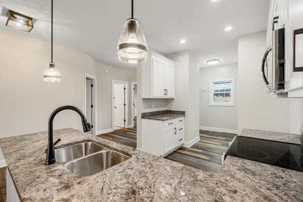 a kitchen with stainless steel appliances granite countertop a sink a stove and a refrigerator
