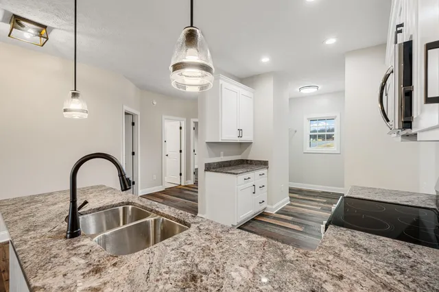 a kitchen with stainless steel appliances granite countertop a sink a stove and a microwave