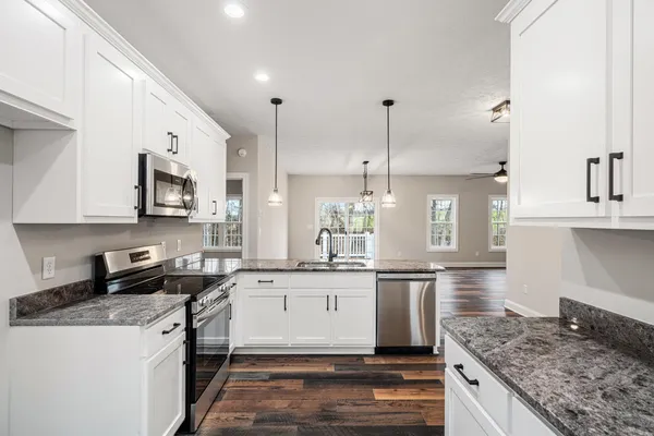 a kitchen with stainless steel appliances granite countertop a sink stove and refrigerator