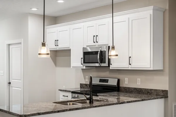 a kitchen with stainless steel appliances granite countertop a sink a stove and a microwave