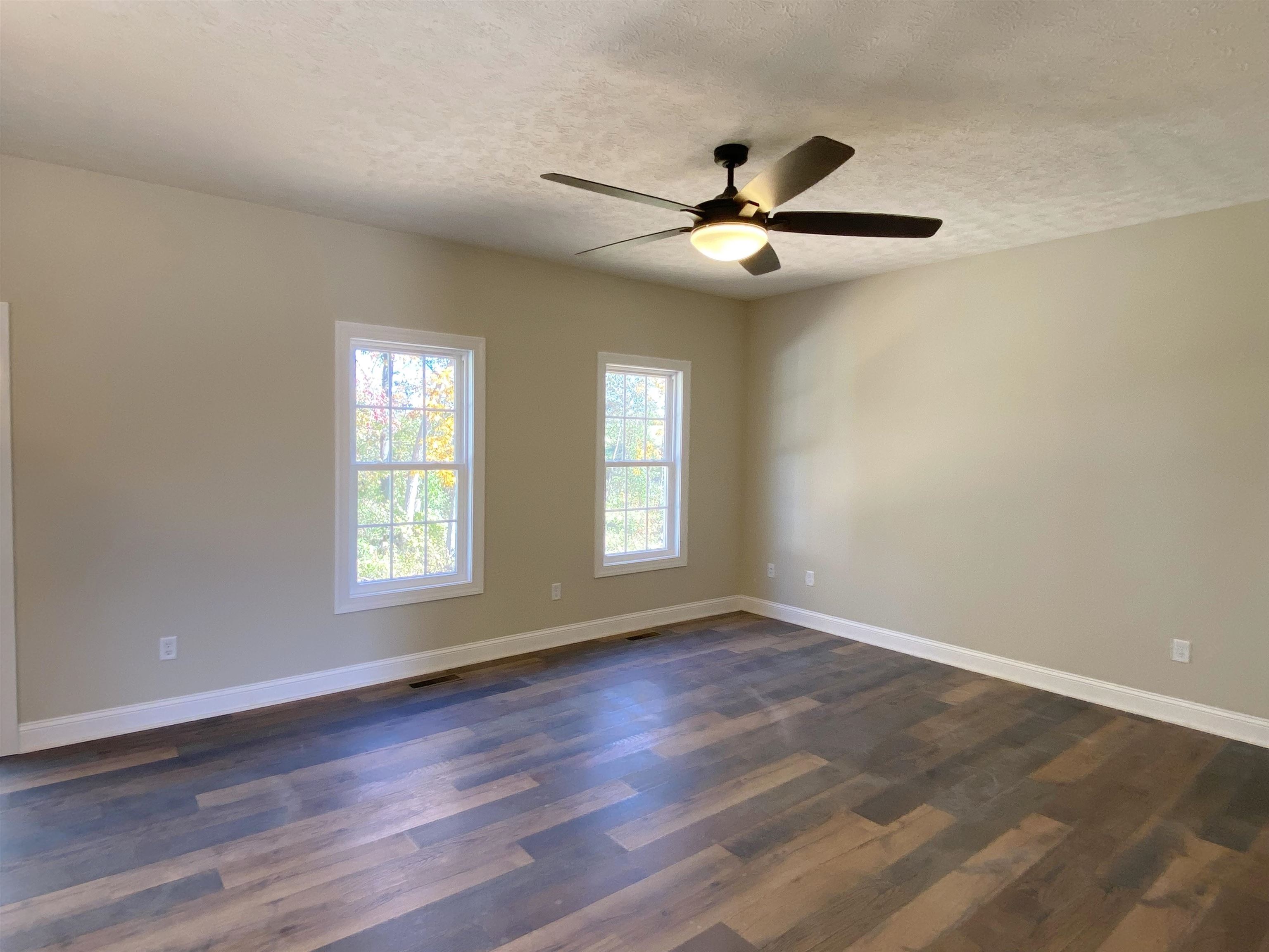 117 Spring Ridge Drive Stuarts Draft, VA 24477 - Photo 5 of 12 an empty room with wooden floor fan and windows