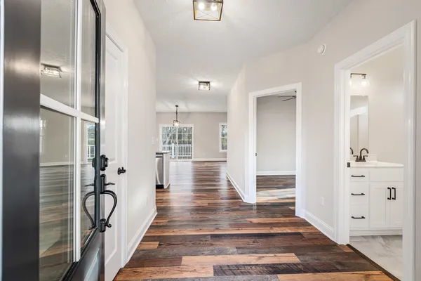 a view of a hallway with wooden floor and staircase