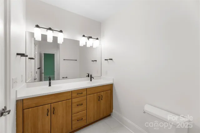 a spacious bathroom with a mirror a shower and a sink