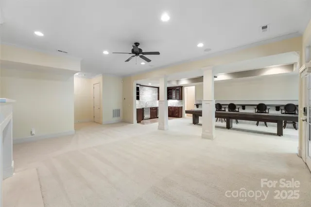 a view of a livingroom with a fireplace a chandelier and windows