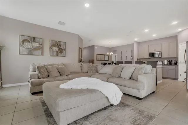 a living room with furniture and a view of kitchen