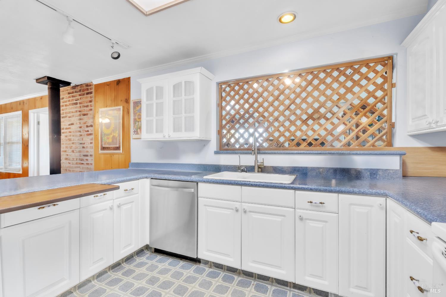 1138 Lokoya Road Napa, CA 94558 - Photo 18 of 28 a kitchen with granite countertop white cabinets and white appliances