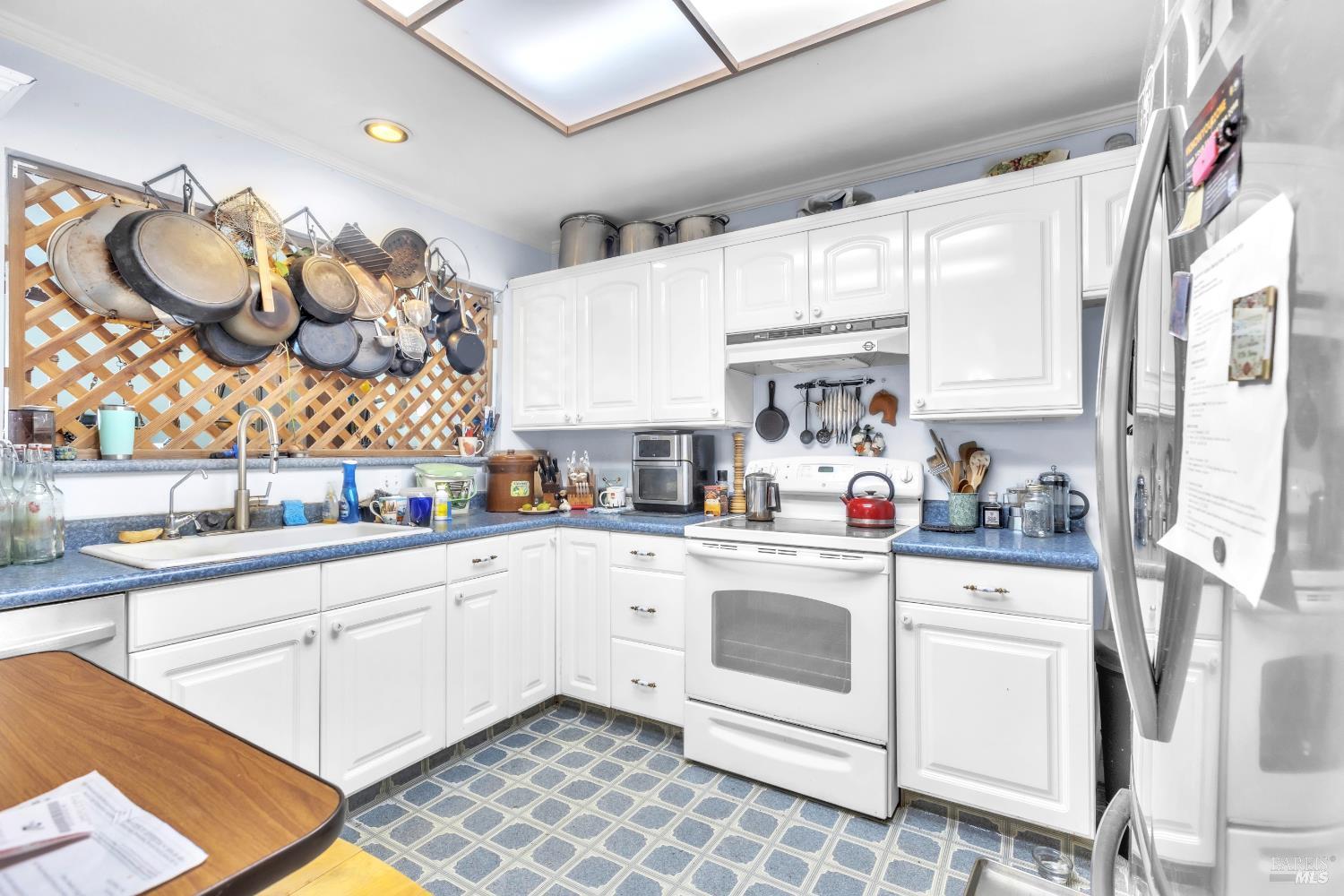 1138 Lokoya Road Napa, CA 94558 - Photo 21 of 35 a kitchen with granite countertop white cabinets and white appliances