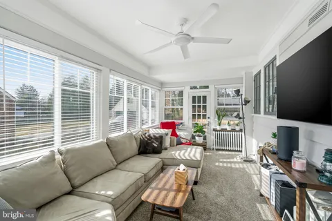 a living room with furniture a flat screen tv and a large window