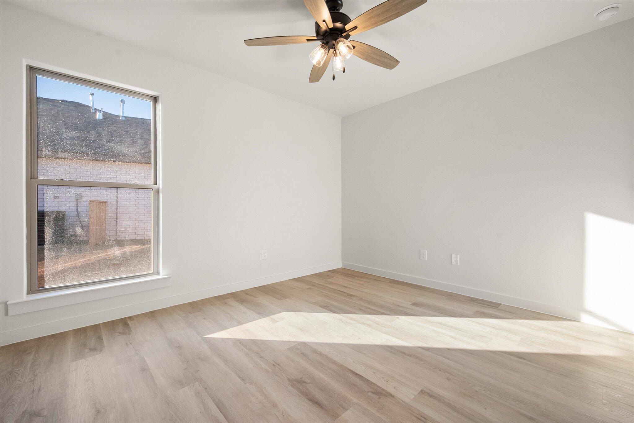 7009 56th Street Lubbock, TX 79407 - Photo 20 of 24 a view of an empty room with wooden floor and a window