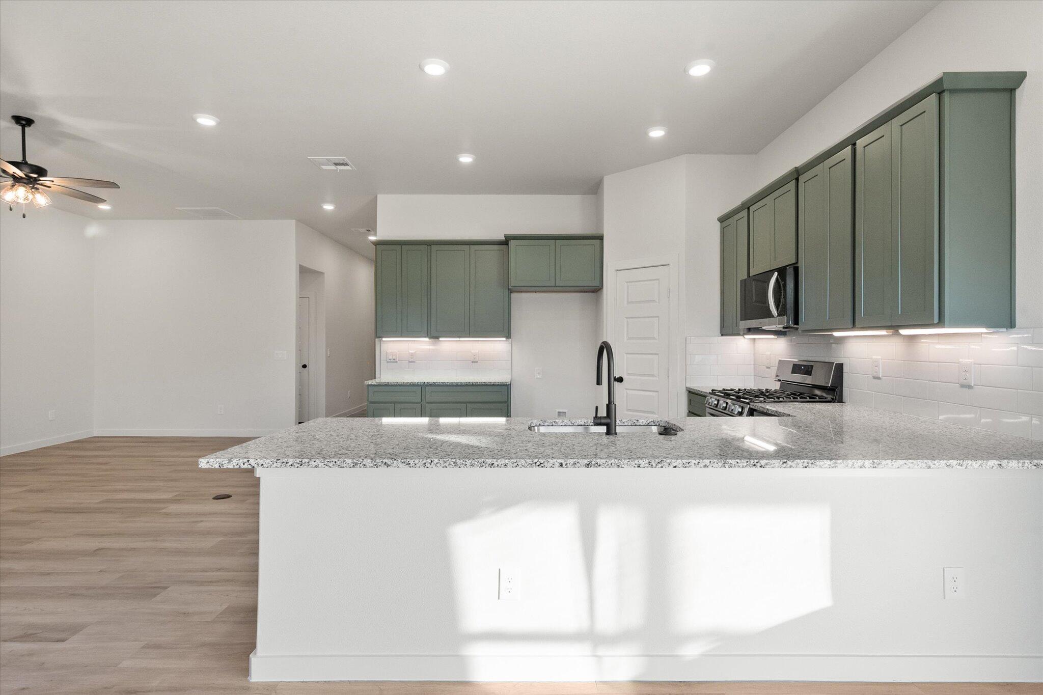 7009 56th Street Lubbock, TX 79407 - Photo 6 of 24 a kitchen with stainless steel appliances granite countertop a sink and a stove