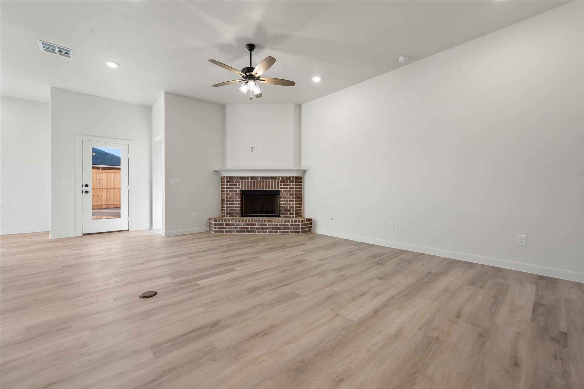 7009 56th Street Lubbock, TX 79407 - Photo 8 of 24 a view of empty room with wooden floor and fan