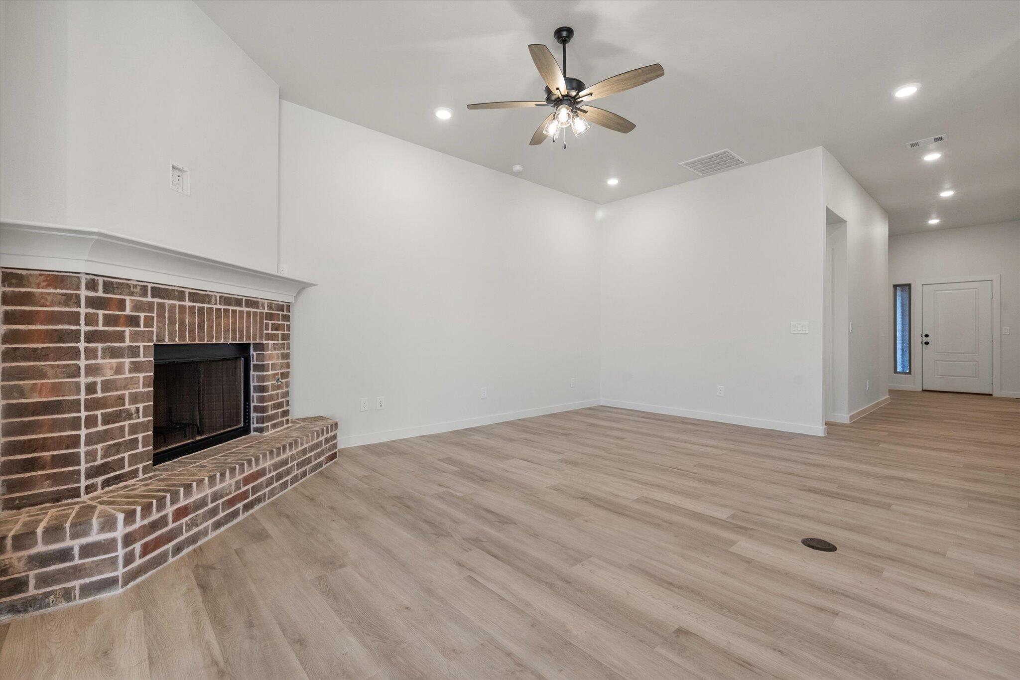 7009 56th Street Lubbock, TX 79407 - Photo 9 of 24 a view of an empty room with a fireplace