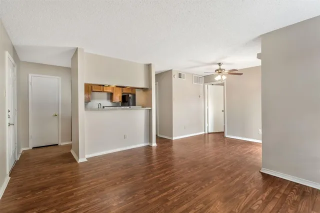 a view of a kitchen with wooden floor and a refrigerator