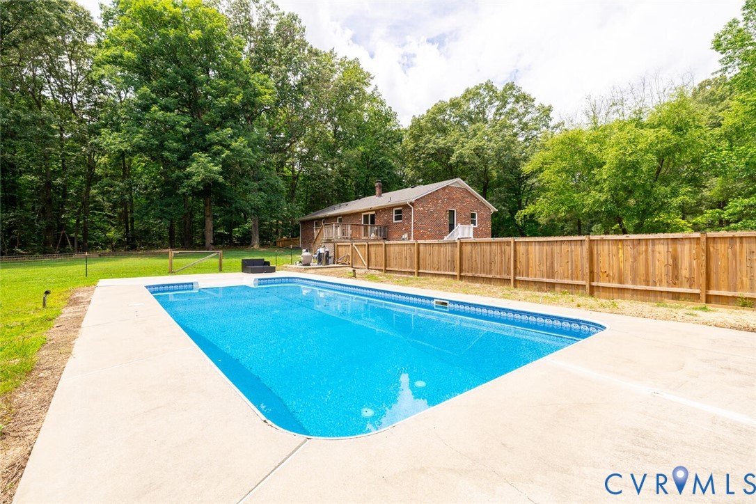 12397 New Market Mill Road Beaverdam, VA 23015 - Photo 30 of 44 a view of a swimming pool with a yard and wooden fence