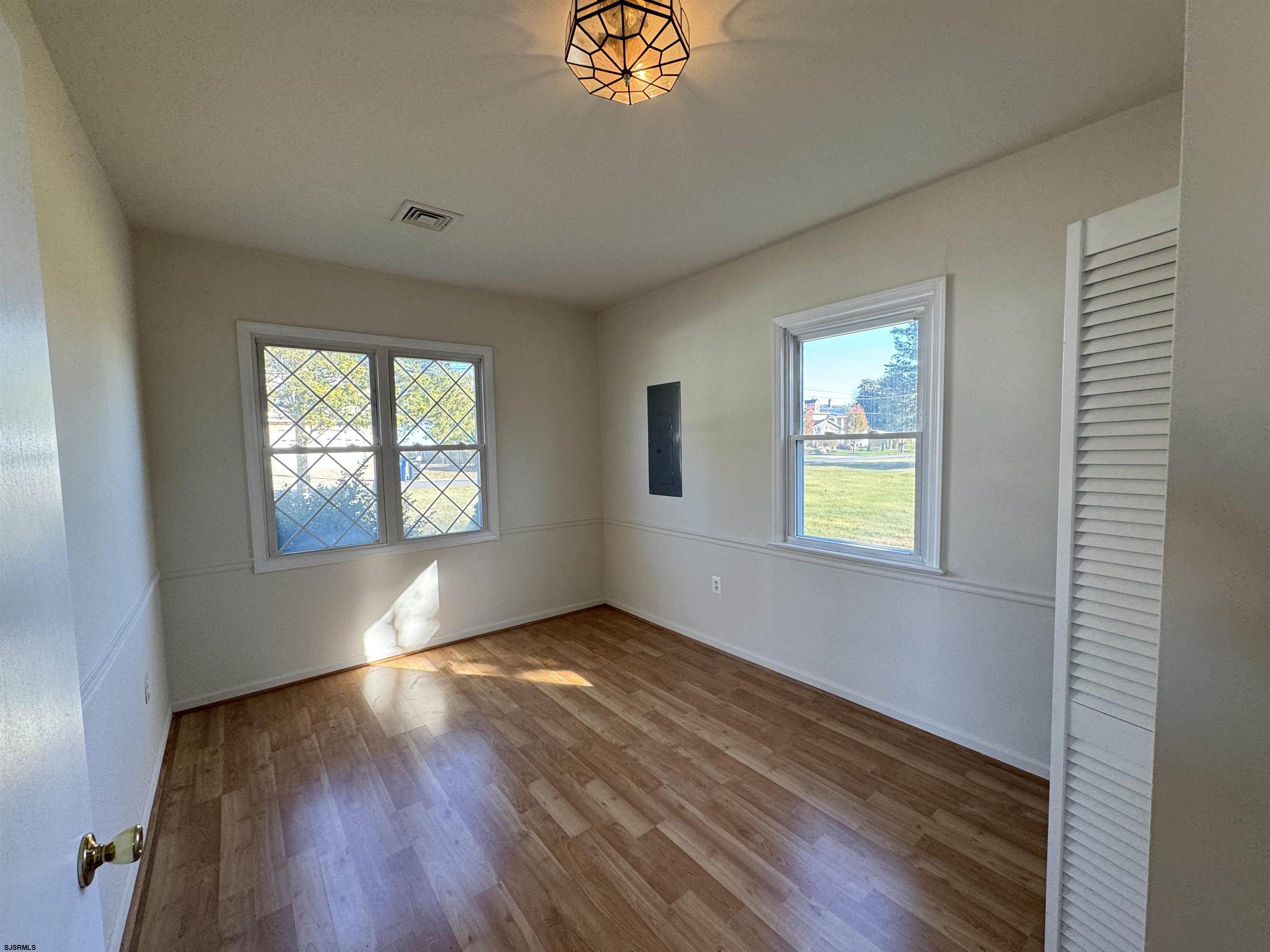 106 Harbor Road Marmora, NJ 08223 - Photo 3 of 11 an empty room with windows and wooden floor