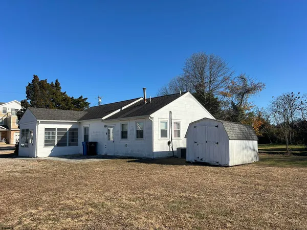 a view of a house with a yard and large tree