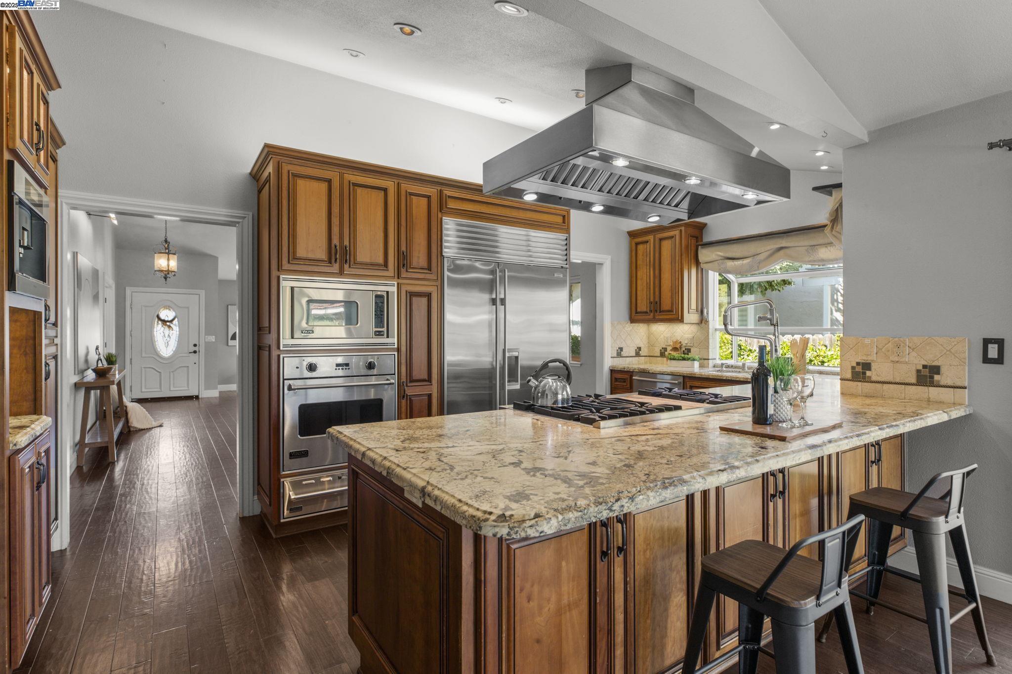 820 Pinehurst Place San Ramon, CA 94583 - Photo 12 of 54 a kitchen with granite countertop a table chairs stove and refrigerator