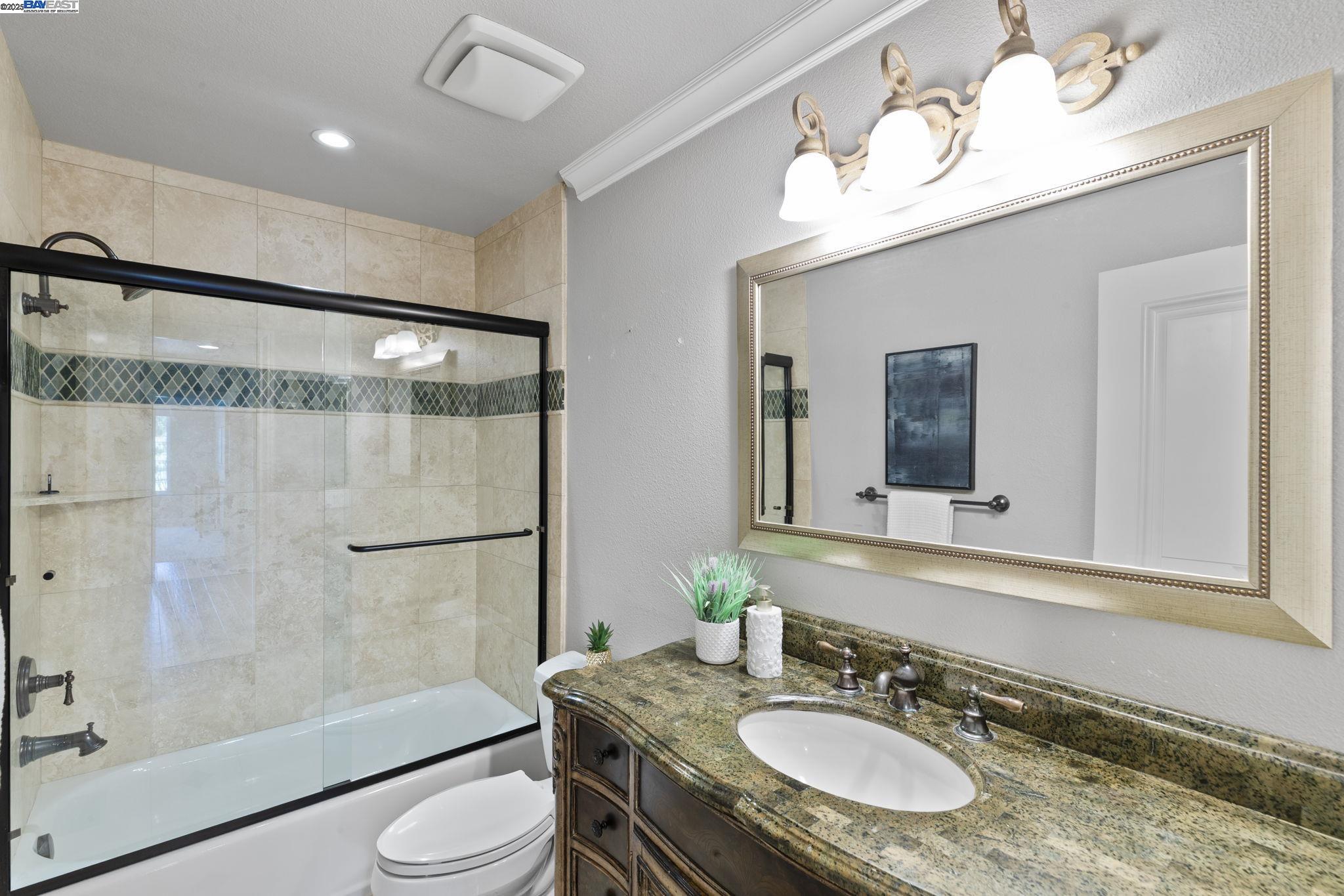 820 Pinehurst Place San Ramon, CA 94583 - Photo 30 of 54 a bathroom with a granite countertop sink toilet mirror and shower