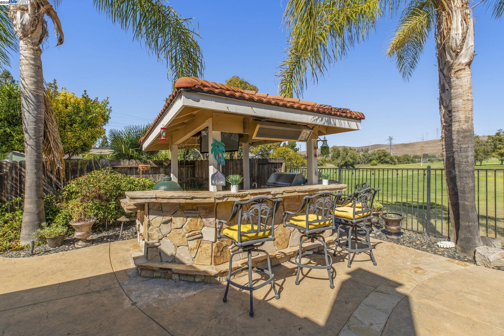 820 Pinehurst Place San Ramon, CA 94583 - Photo 41 of 54 a view of a patio with a table and chairs under an umbrella with palm trees